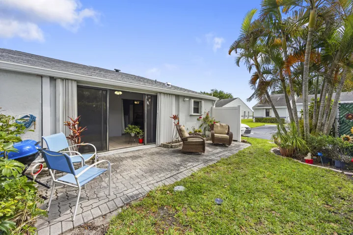 Charming outdoor patio space featuring a paver deck, perfect for relaxing or entertaining. Surrounded by lush tropical landscaping and privacy fencing, this inviting backyard offers a peaceful setting with plenty of room for outdoor seating, grilling, and enjoying the South Florida lifestyle.