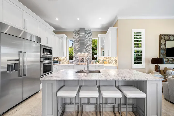 Large kitchen Island with seating for four and marble countertops.
