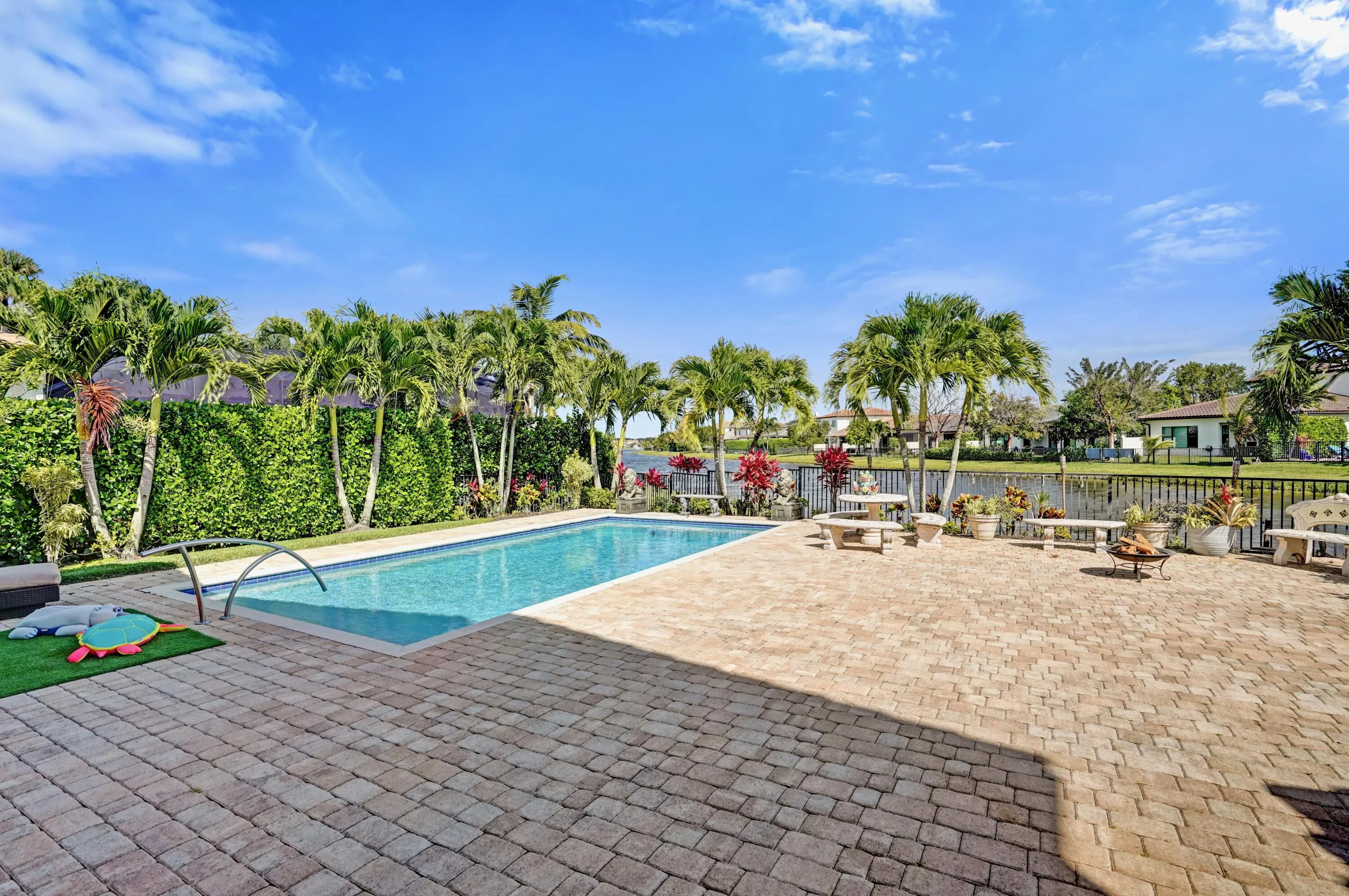 Large pool with extended paver patio and lake view.
