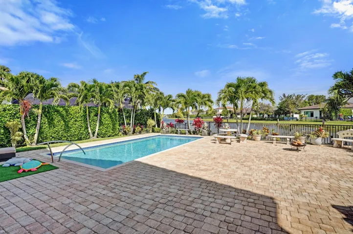 Large pool with extended paver patio and lake view.