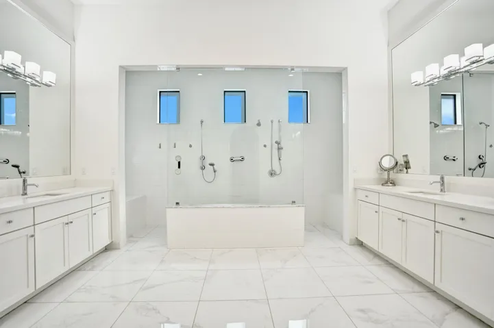 Large primary bathroom with oversized double shower and double vanities.