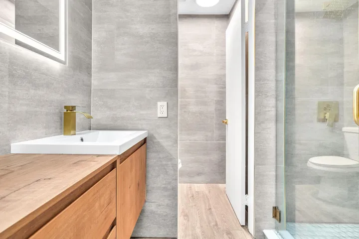 Primary Bathroom #1 with Floor to Ceiling Tile & Floating Natural Wood Vanity