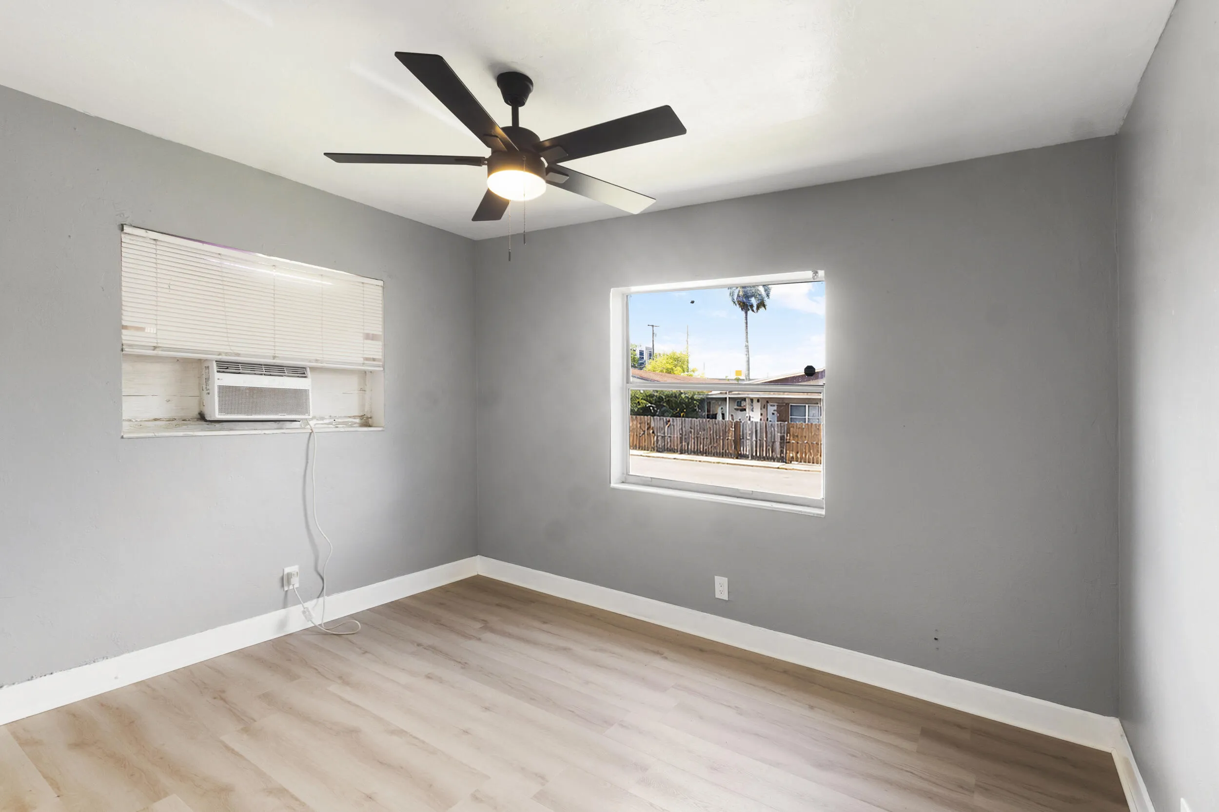 Second bedroom with a window unit and a ceiling fan.