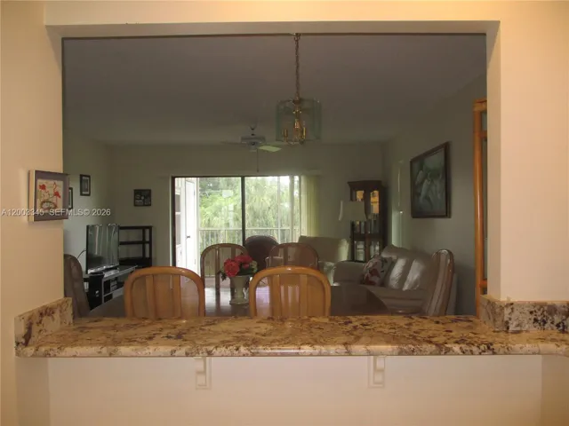 LARGE OPENING INTO THE DINING AREA WITH GRANITE COUNTERTOP