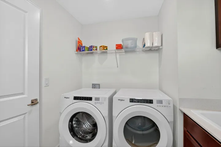 Laundry features built in cabinets and wash sink .