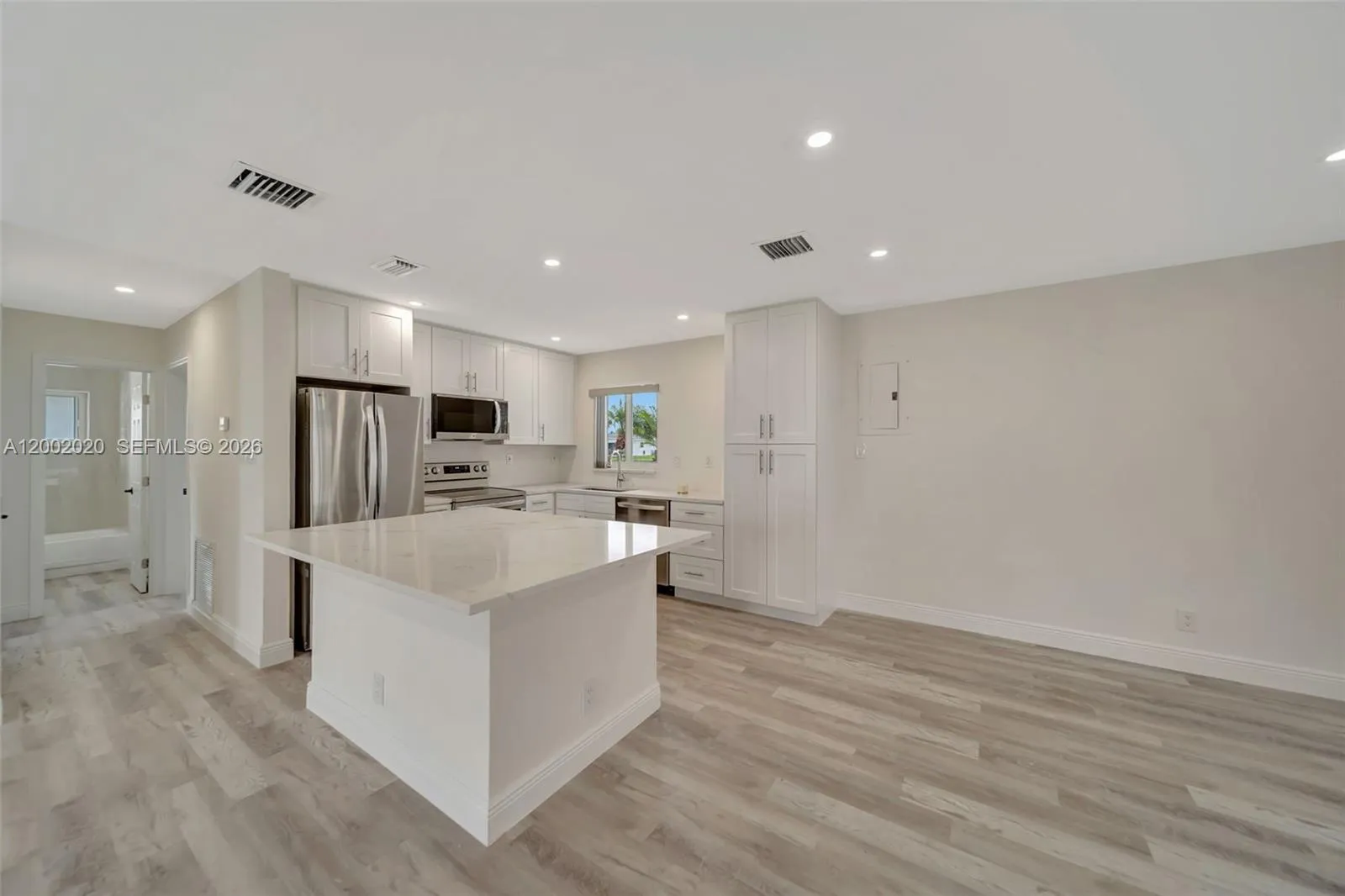 Kitchen island and cabinetry detail and facing towards the Hallway area to bedrooms