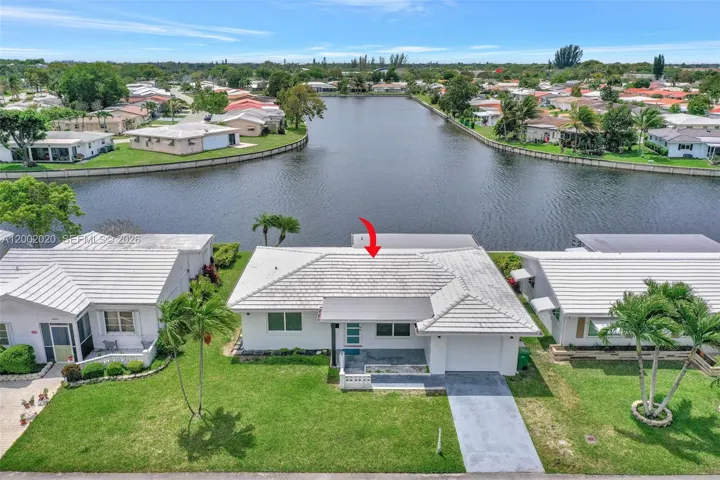 Aerial — home positioned on lake with community context