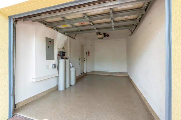 Garage with updated flooring, water softener system, and updated electrical box