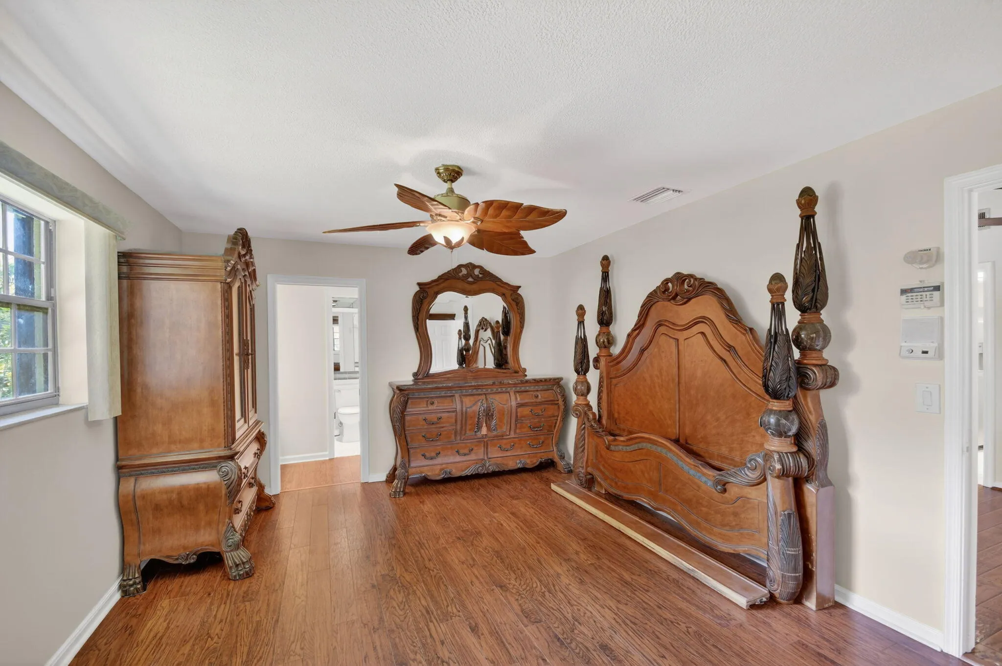 Primary bedroom boasts wood laminate flooring, fresh paint