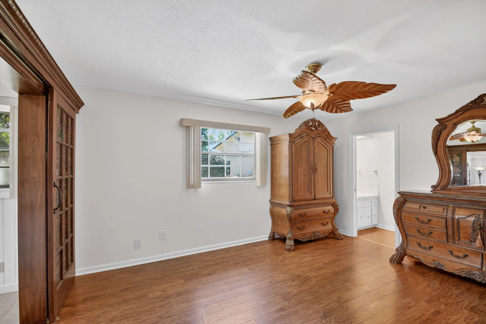 Primary bedroom boasts wood laminate flooring, fresh paint