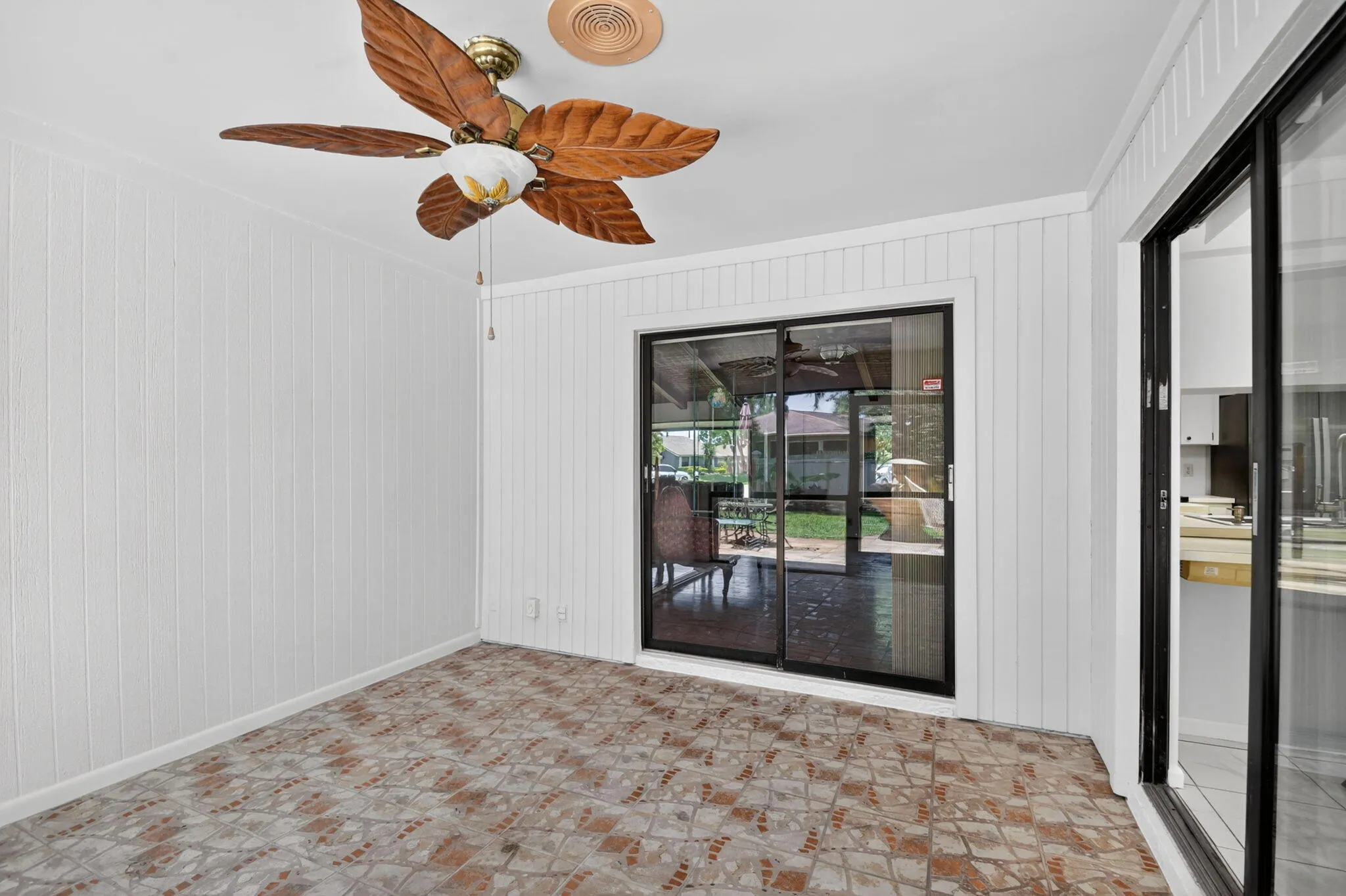 Covered patio leads to extended paver patio and expansive back yard