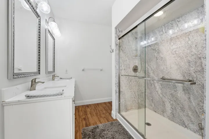 Updated bath with double sinks and walk-in shower.