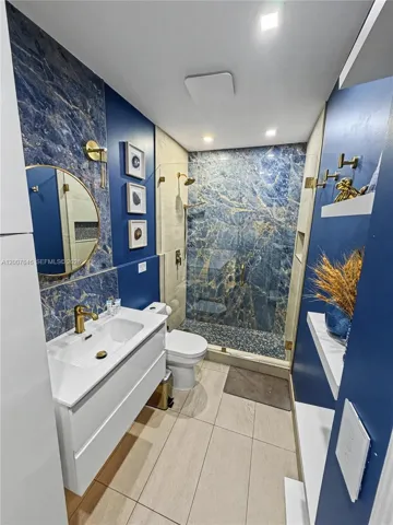 Beautifully renovated bathroom with designer blue-tile accent walls