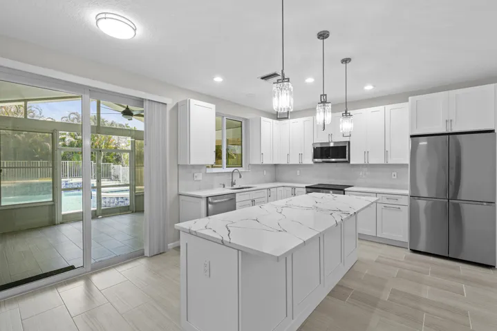 Exquisitely updated kitchen overlooking the spacious patio and backyard oasis.