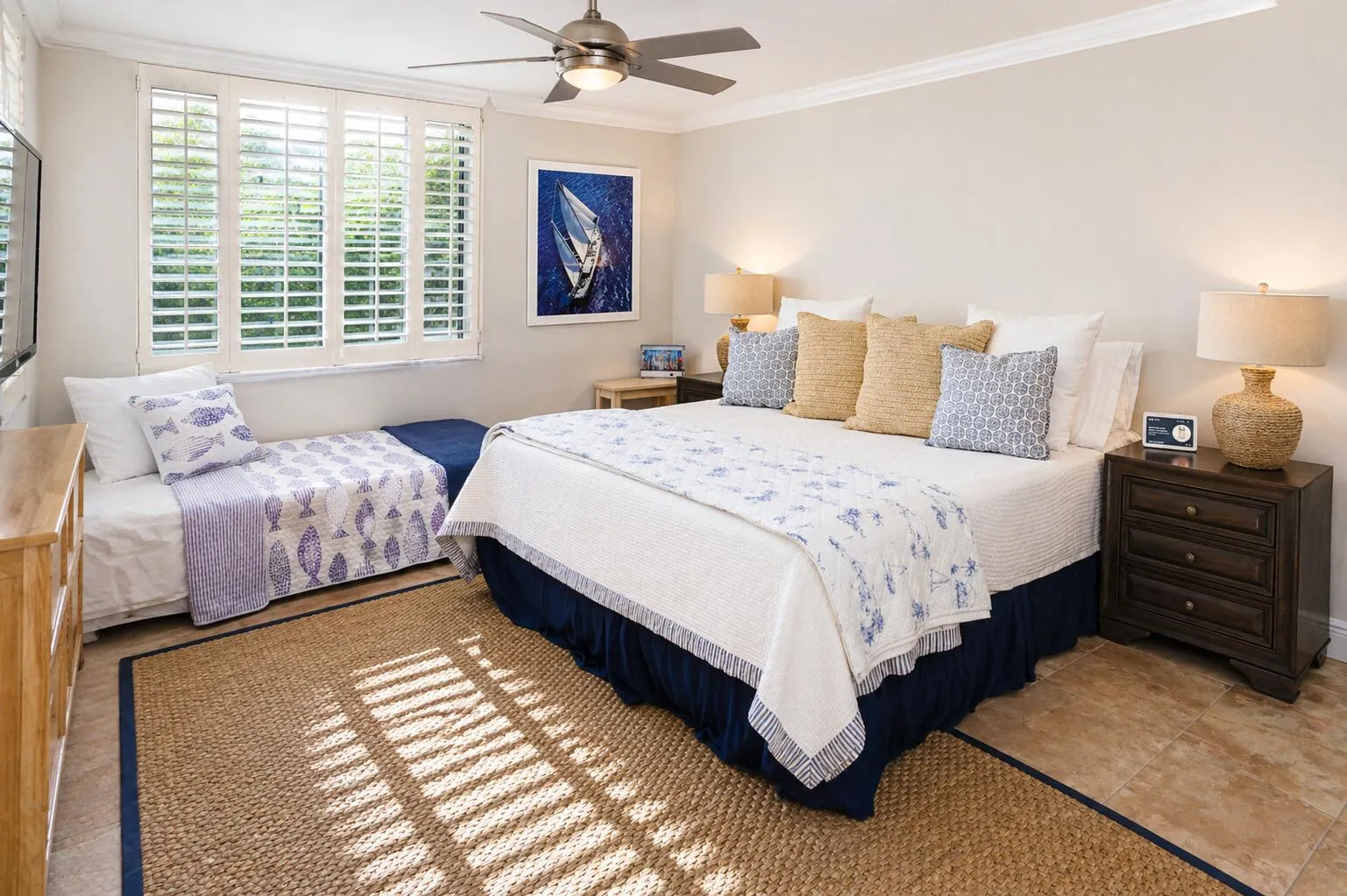 Primary Bedroom – Generous space featuring a king bed and plantation shutters.
