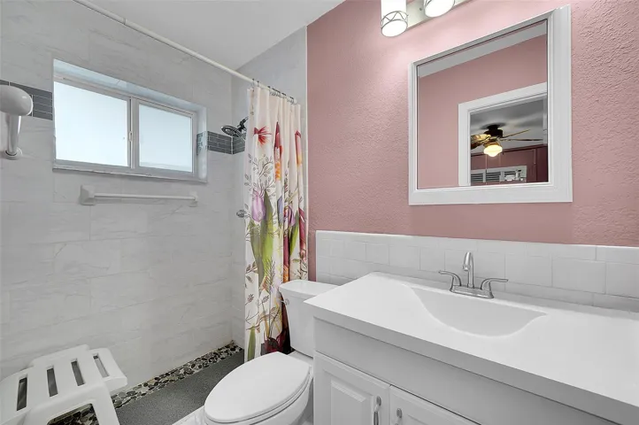 Primary bath with tiled shower and large vanity