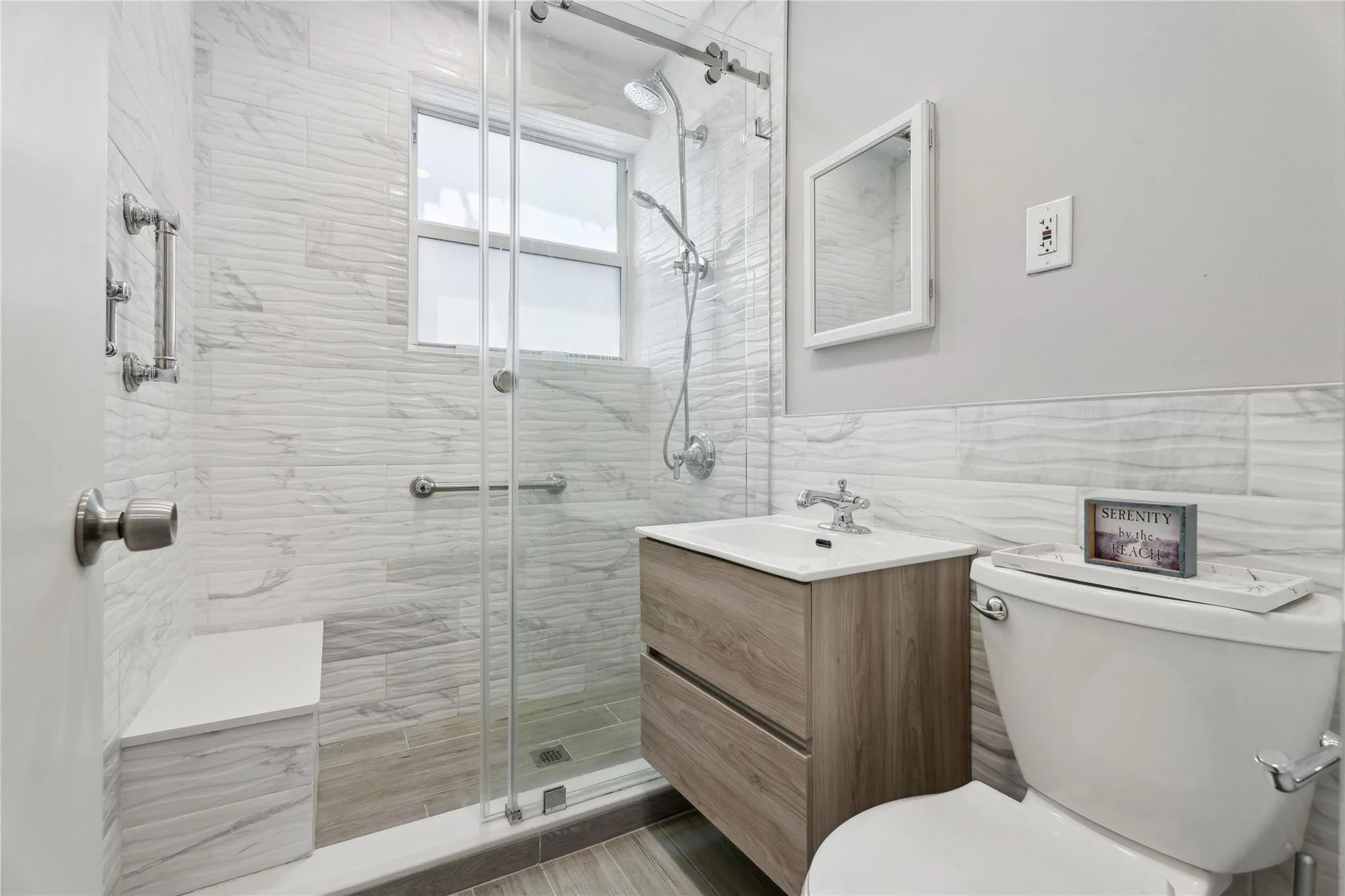 Remodeled modern bathroom all tiled large step in shower with seat