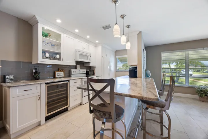 Remodeled, open kitchen with granite countertops & white shaker style cabinets