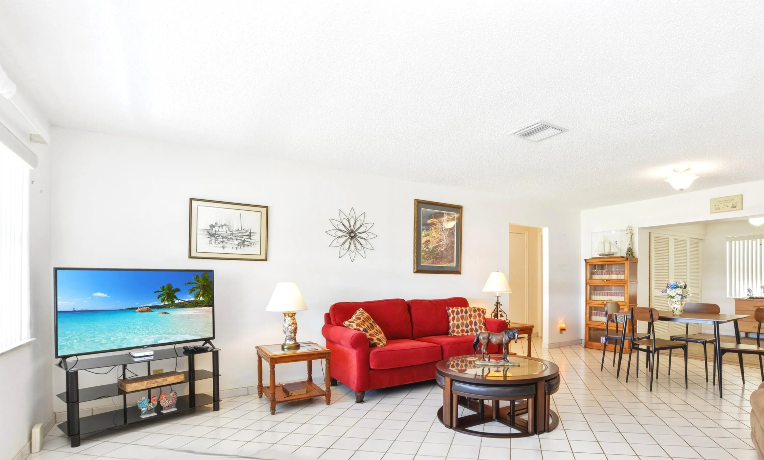 Spacious living room with hurricane impact window and neutral tile floor