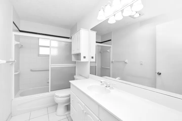 Updated guest bathroom with glass enclosed tub/shower.