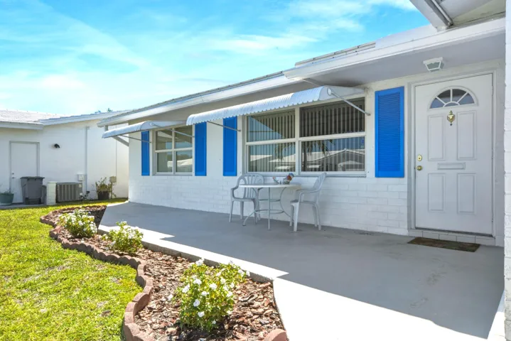 Tiled Front Porch with awnings for shade. ALL HURRICANE IMPACT WINDOWS THRU OUT.