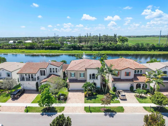 An Aerial view of this pretty 2 story home with the lake and fountain behind,