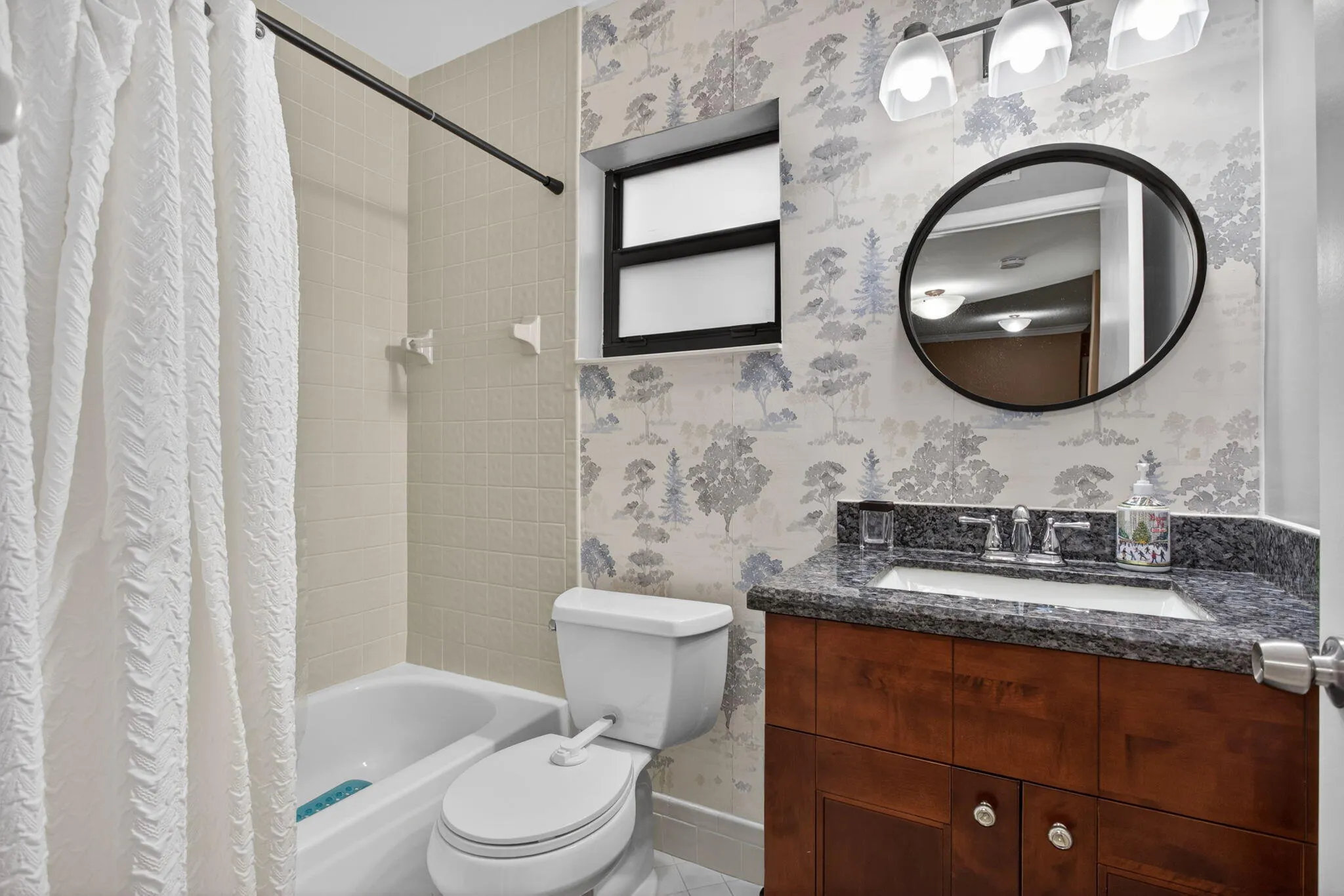 the second bath has a newer vanity, mirror and accent wall.