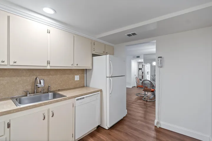 Kitchen with basic water filter at sink and refrigerator/freezer.