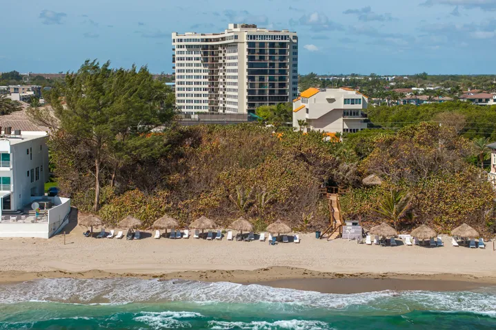 View of lounges & umbrellas on private beach area.