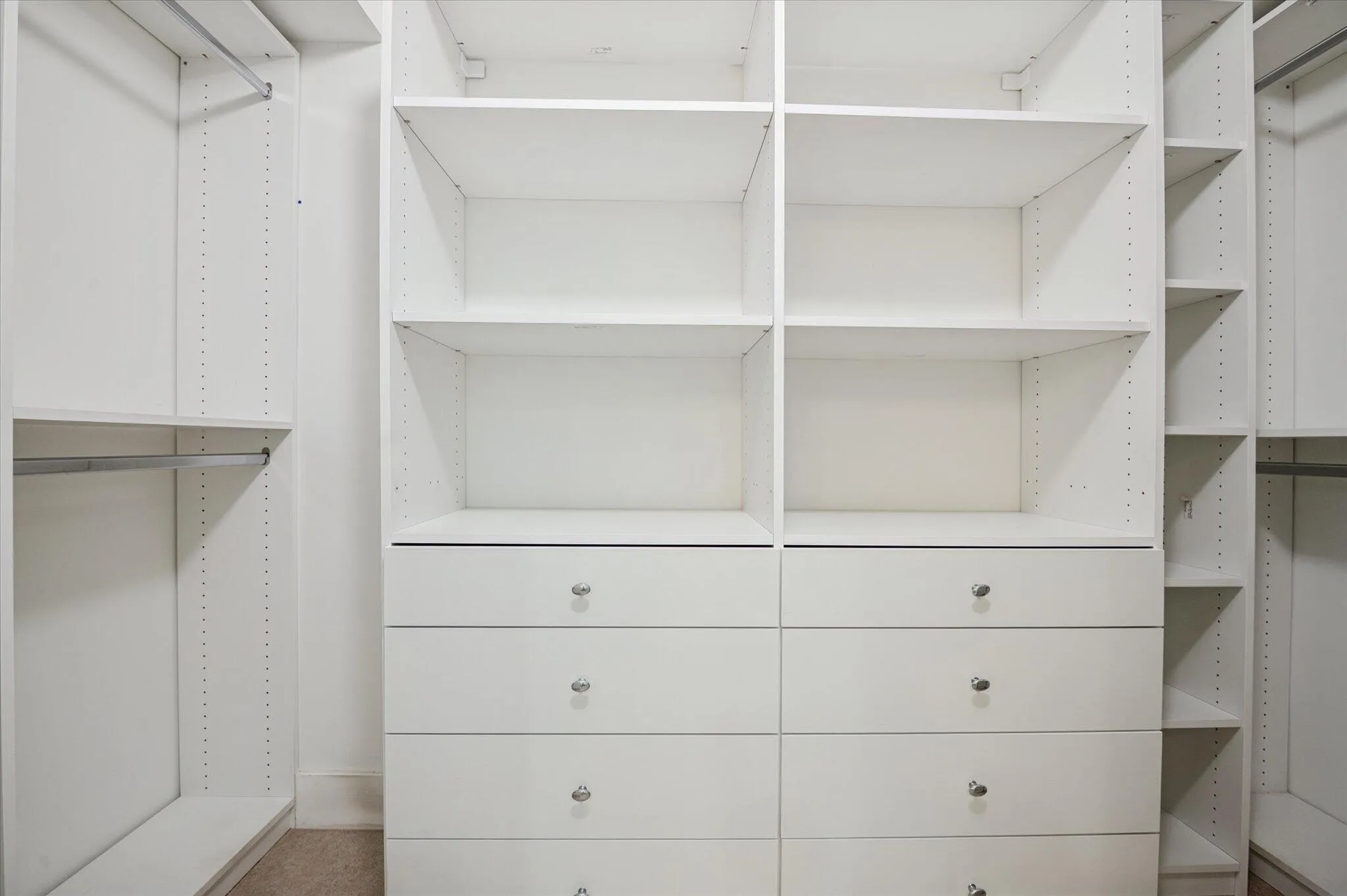Custom walk-in closet with built-in shelving, drawers, and ample hanging space for optimal organization.