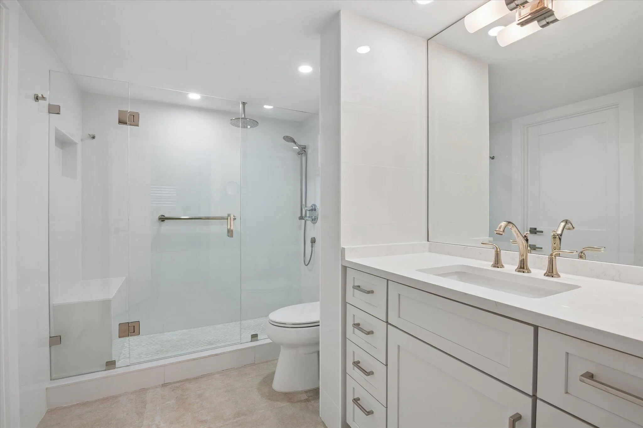 Spa-inspired bathroom with frameless glass walk-in shower, rain head, and sleek modern finishes.
