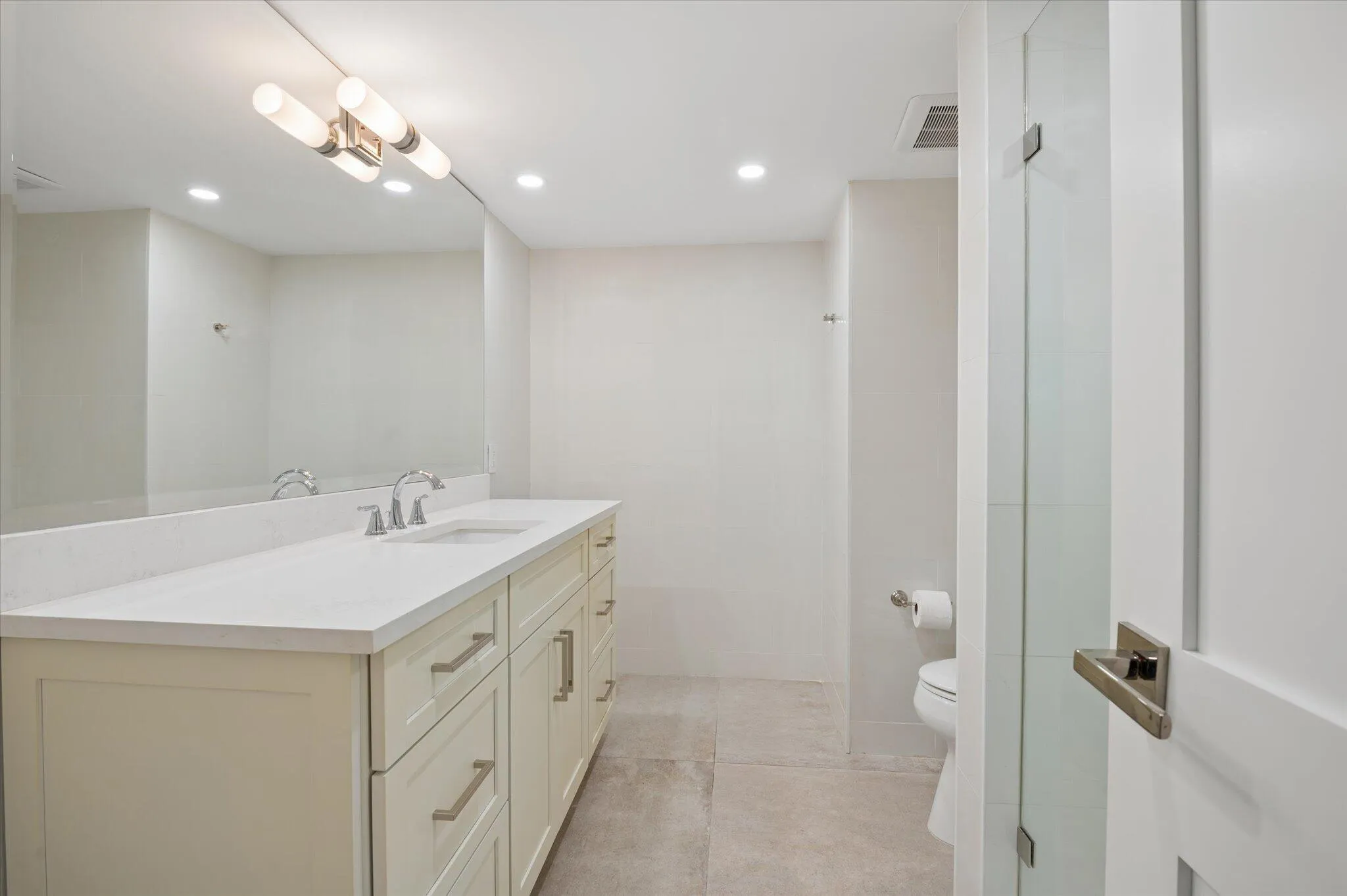 Updated bathroom with quartz countertops, shaker cabinetry, and contemporary lighting.