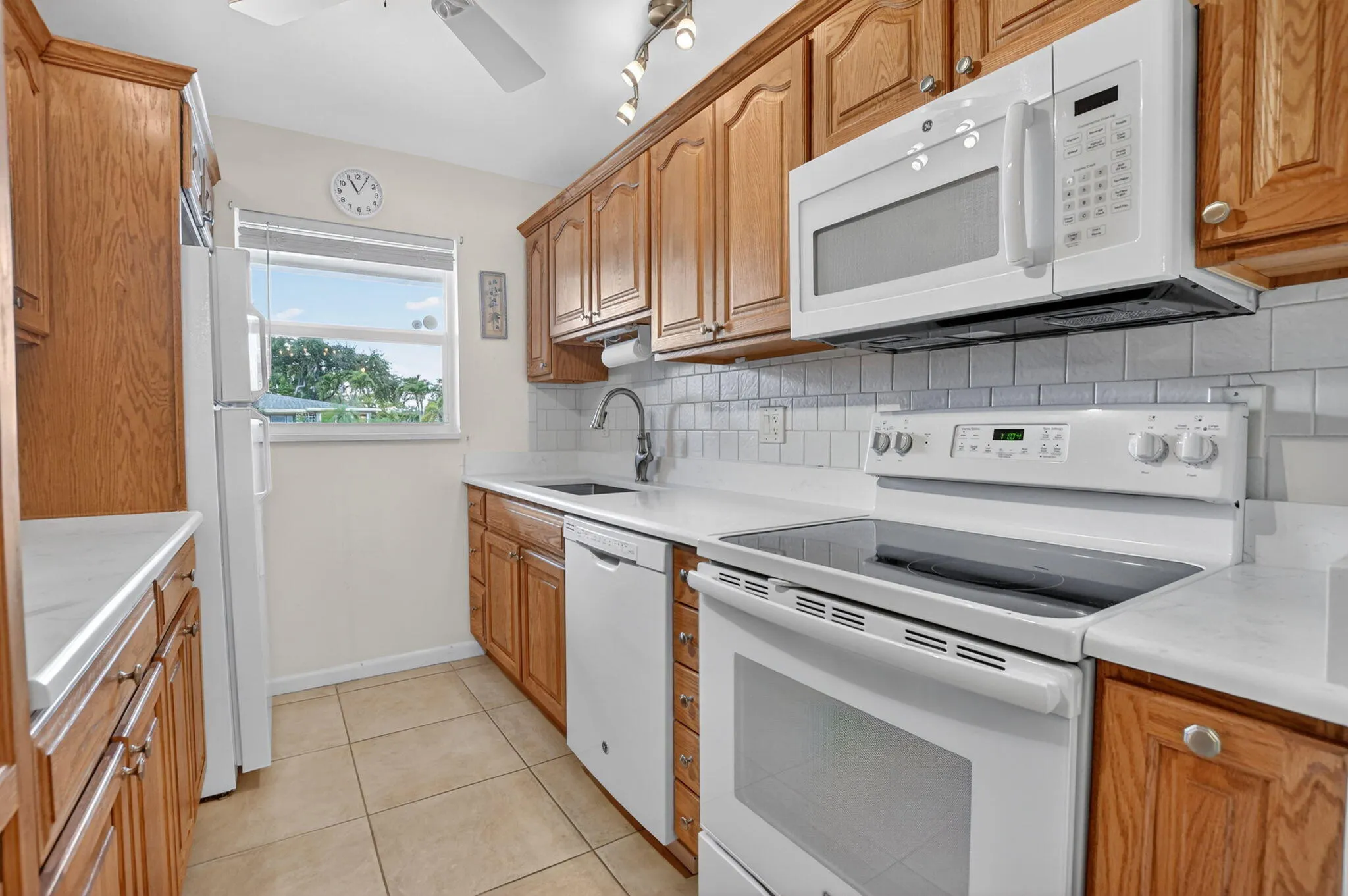 Well appointed Kitchen with Quartz counter and tile back backsplash