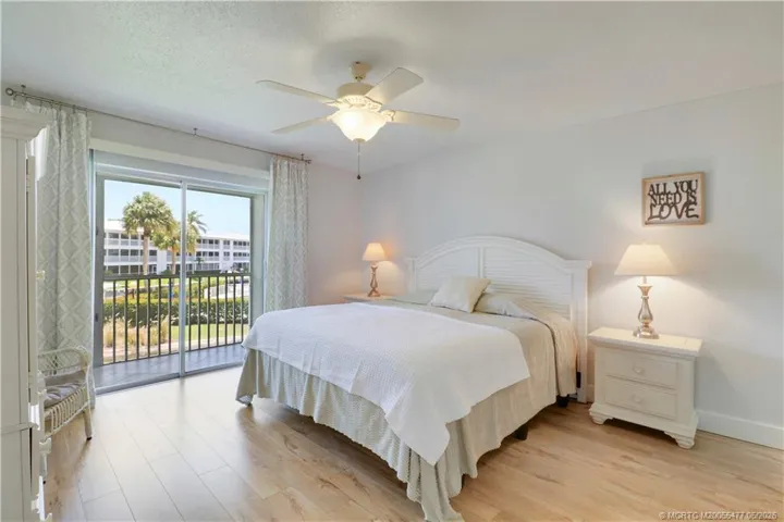 Peaceful primary suite featuring luxury vinyl plank flooring, large sliding glass doors to the screened lanai, abundant natural light, and tranquil tropical views. Spacious ensuite bath with dual sink vanity and generous storage.