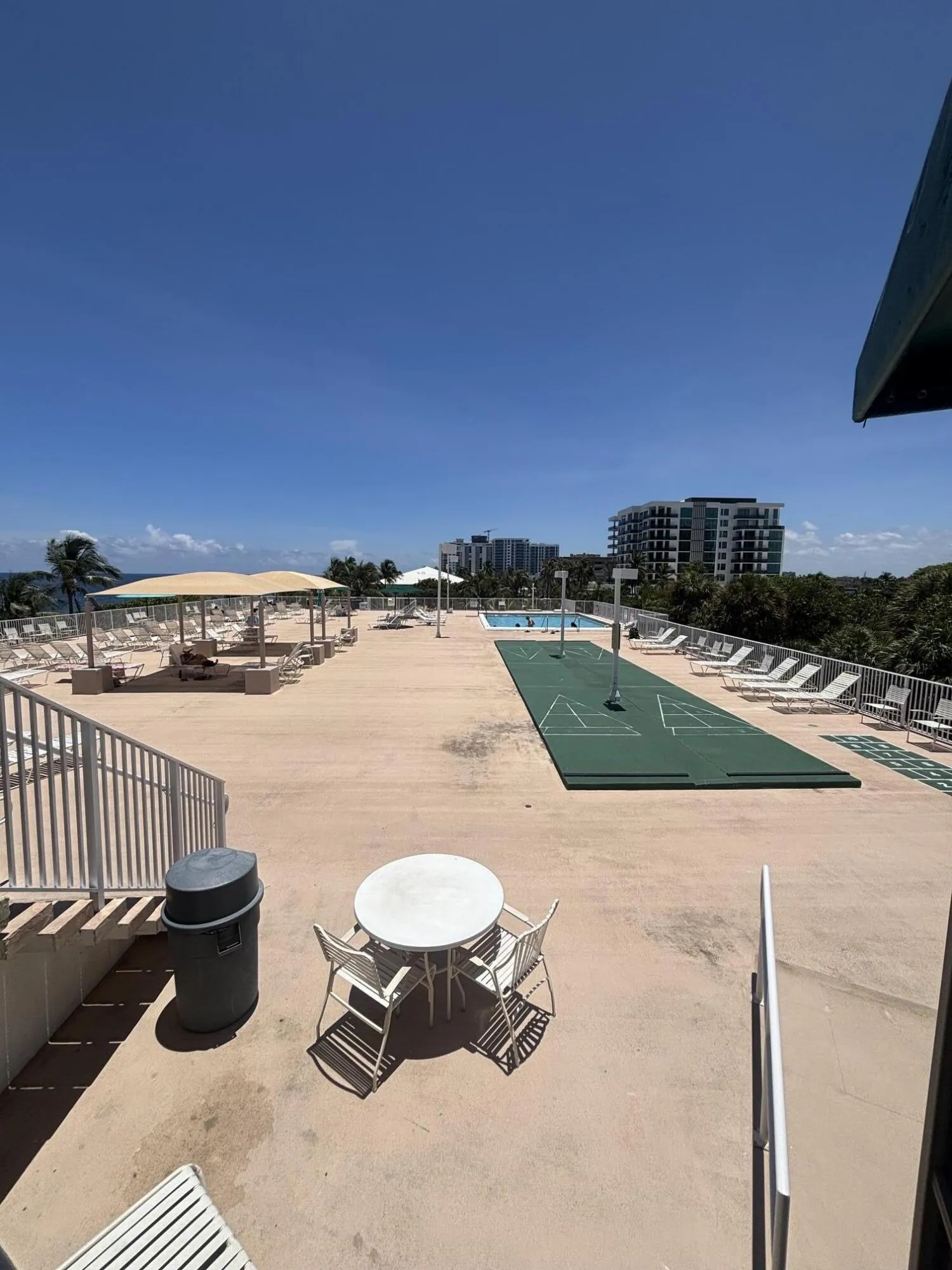 Oceanfront terrace featuring the pool, shuffleboard and plenty of lounge chairs.