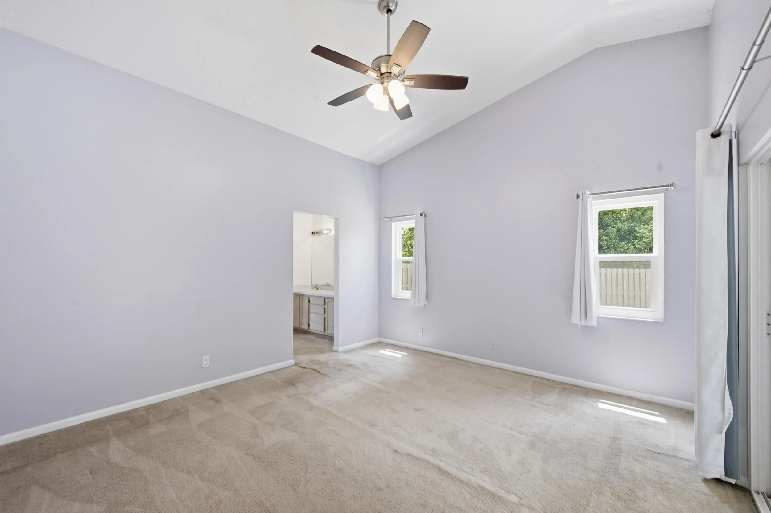 Primary bedroom with vaulted ceilings.
