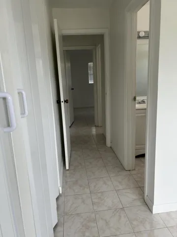 View toward the second bedroom at the end of the hallway. The second bathroom, to the right, is easily accessible to guests.