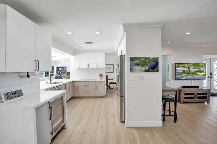 View of Kitchen with Family room to right (Drybar with beverage/wine cooler to left)