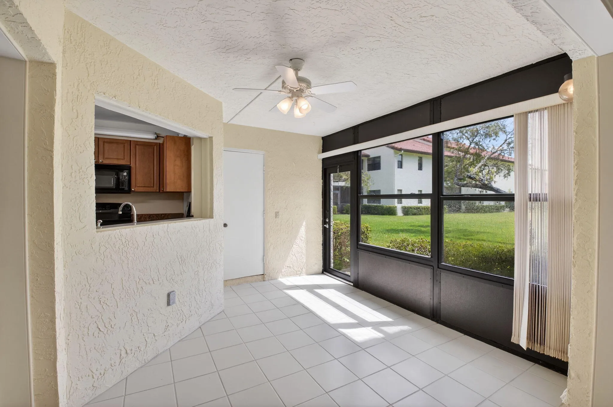 The Florida room overlooking expansive green space and lush landscaping.