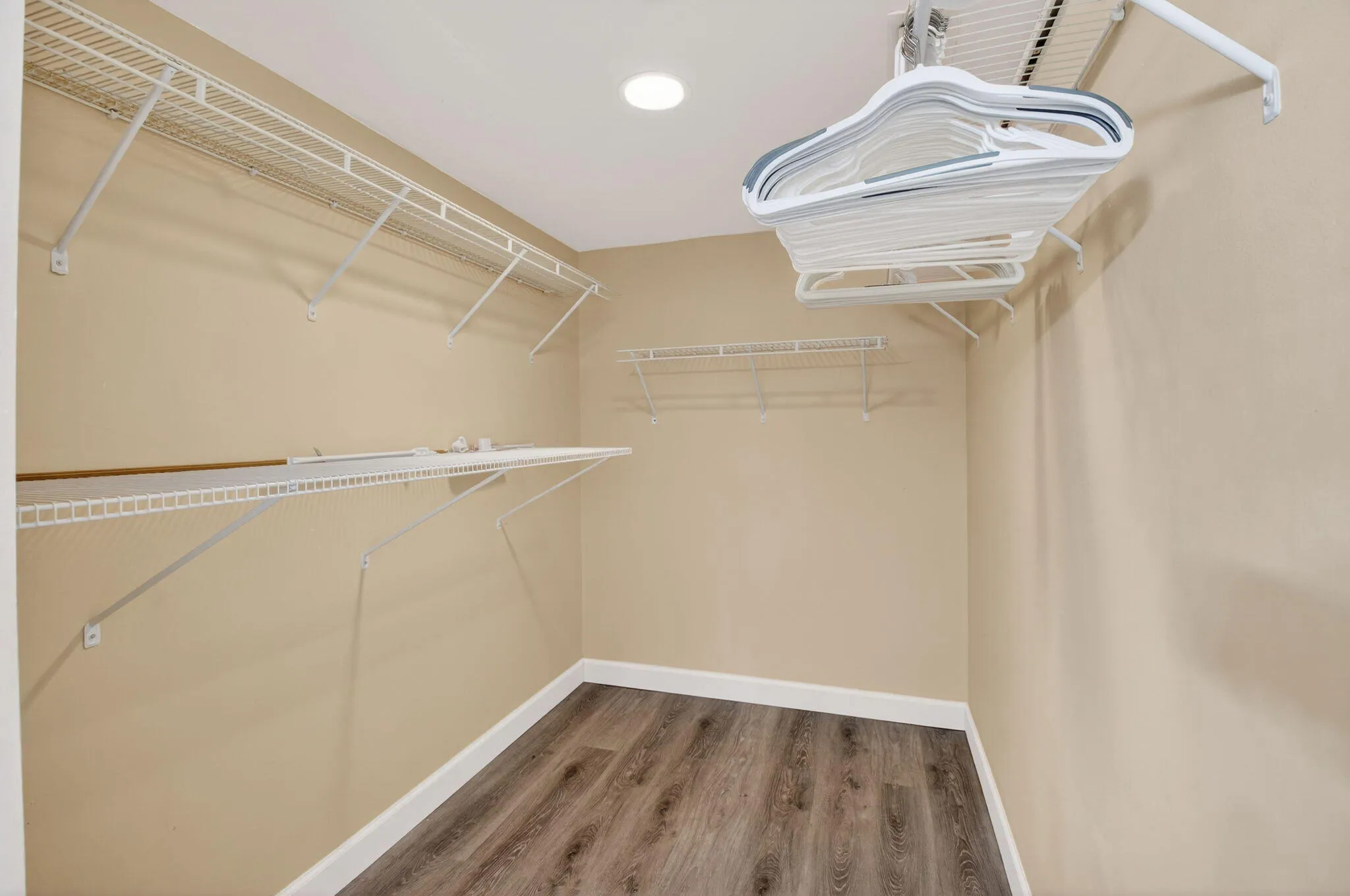 Spacious walk-in closet with built-in shelving for organized storage.