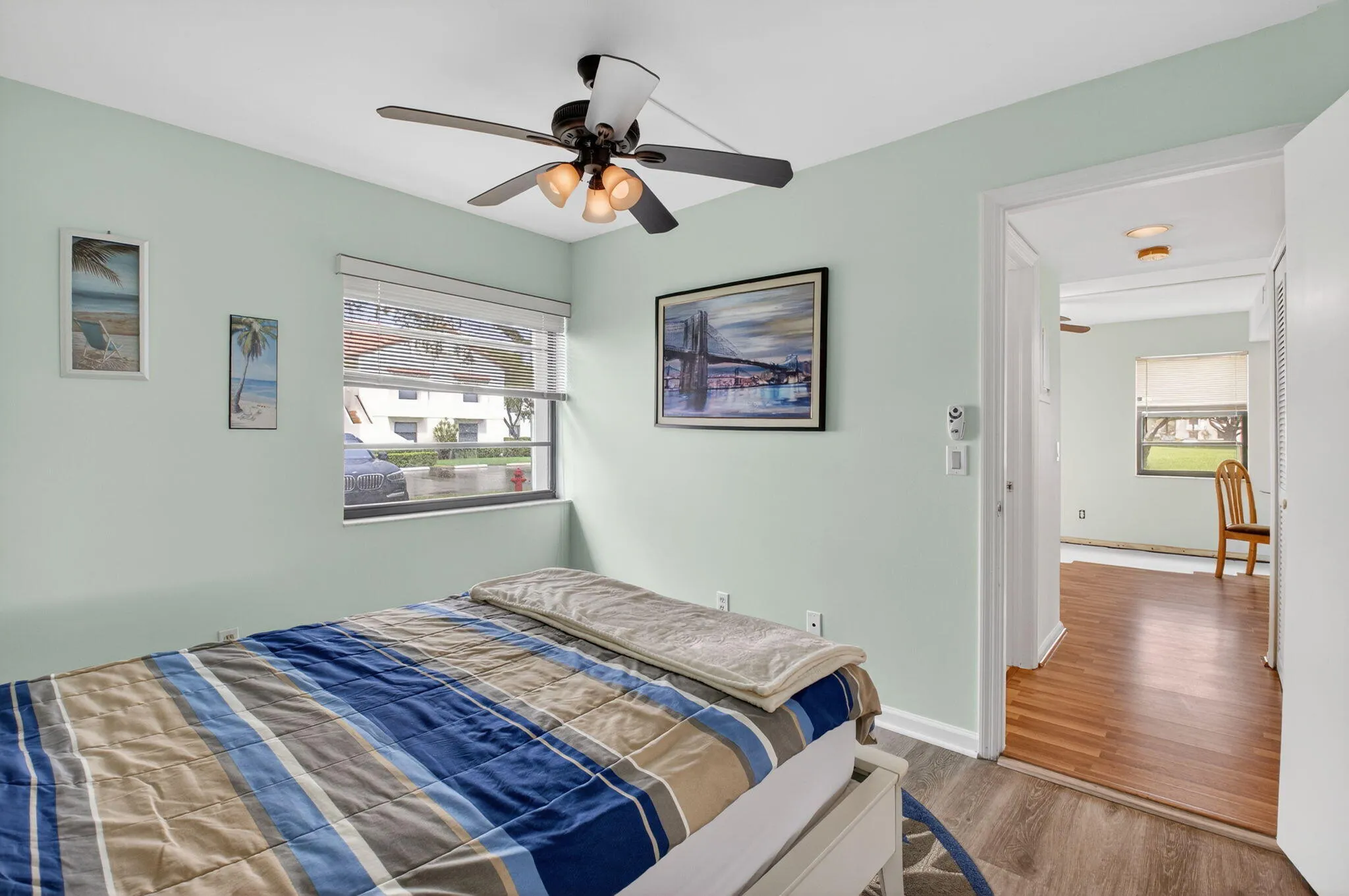 Secondary bedroom with natural light, ceiling fan, and neutral finishes.