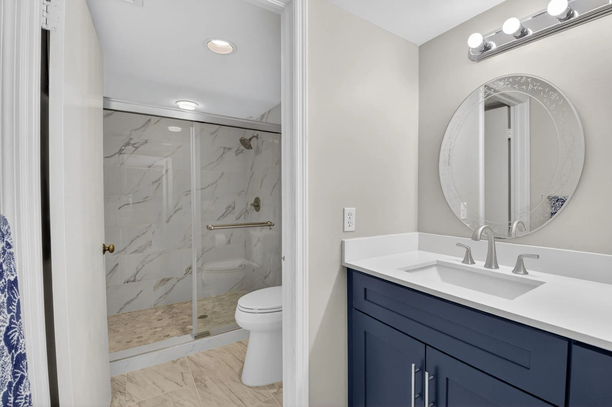 Remodeled primary bath with updated vanity and beautifully tiled walk-in shower.