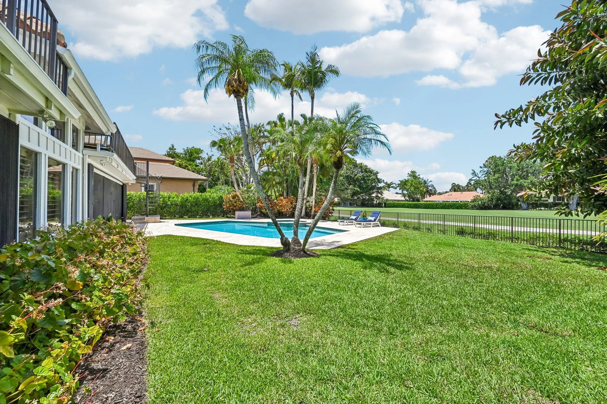 The backyard offers abundant green space, providing an ideal setting for a private putting green or custom outdoor enhancements.