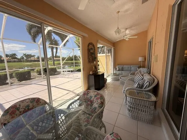 Sunroom is glassed with sliders out to huge screened patio