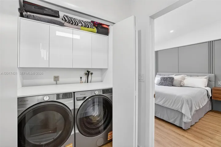 Laundry next to primary bedroom w/ folding counter and extra storage