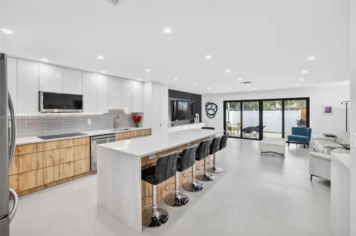 WOW! Beautiful porcelain flooring, huge center island w/ waterfall quartz counter & counter seating.