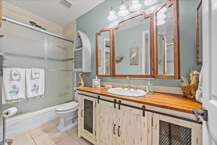 Custom updated guest bath with barn door vanity and rain glass shower door and added comfort height toilet...