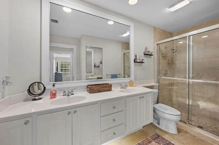 Primary bathroom - featuring a tiled shower and dual sinks