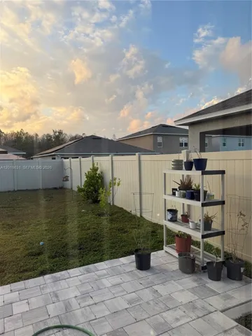 FENCED PATIO WITH PARTIALLY PAVED TERRACE