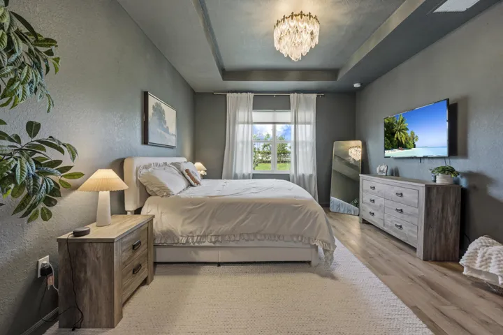 Relax in a spacious owner's retreat featuring elegant tray ceilings and peaceful backyard views.